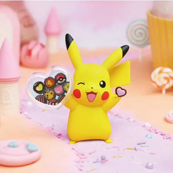 Figurine Pikachu Bonbon tenant un bonbon en forme de cœur dans un décor coloré de pays des bonbons.