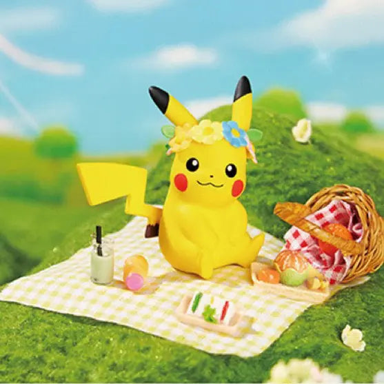 Pikachu Picknick Figure Can with picnic items on a blanket in a grassy landscape.