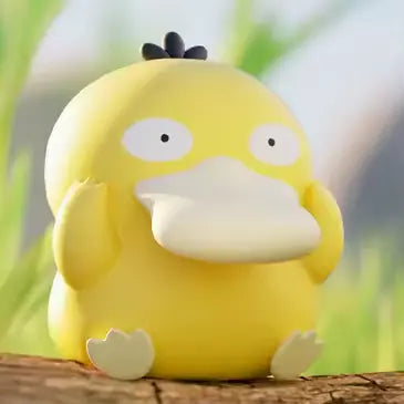 Boîte surprise de mini-figurines Pokémon avec une adorable figurine jaune de Psykokwak sur une surface en bois dans la nature.