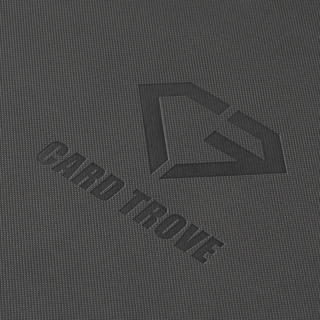 Nahaufnahme der texturierten Oberfläche mit dem CARD TROVE-Logo auf dunklem Hintergrund.