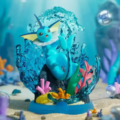 Détendez-vous et profitez de la boîte surprise Evee mettant en vedette Vaporeon dans un diorama sous-marin vibrant avec des coraux colorés.