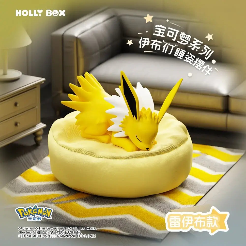 Boîte surprise Eeveelution endormie mettant en vedette un Voltali endormi sur un coussin jaune.