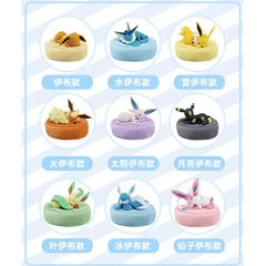 "Boîte surprise Eeveelution endormie comprenant 9 figurines Eeveelution endormies aléatoires avec coussins assortis."