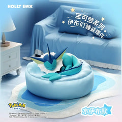 Boîte surprise Eeveelution endormie mettant en vedette Aquali sur un coussin douillet.
