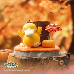Psyduck Pokémon Nature Figure sitting on a stump with an autumn backdrop and pumpkin decoration.
