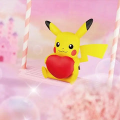 Pikachu Heart Figure Can featuring Pikachu with a red heart on a swing in a whimsical setting.