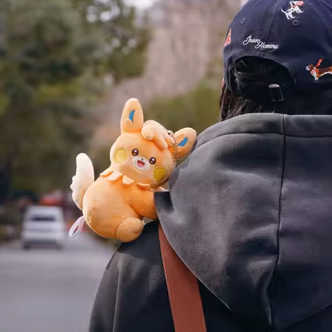 Pokémon Plush and Card Blind Box featuring a cute plush on a person's shoulder outdoors.