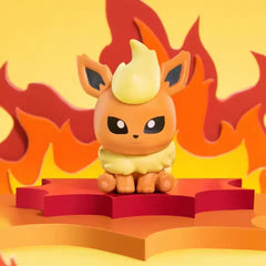 Boîte surprise de mini-figurines Eeveelution avec une figurine de Pokémon de feu sur un fond coloré.