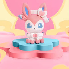 Boîte surprise mini-figurine Eeveelution avec une adorable figurine Sylveon sur une base de fleur colorée.