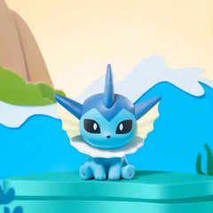 Boîte surprise de mini figurines Pokémon Eeveelution avec figurine Aquali sur fond panoramique.