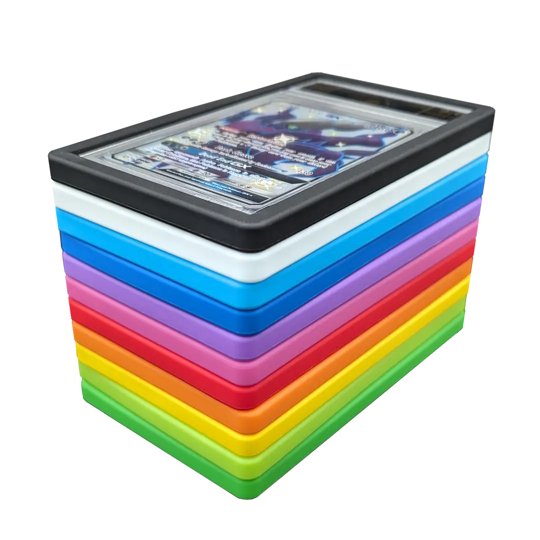 PSA Slab Bumper - Black, PSA Slab Bumper - White, PSA Slab Bumper - Purple, PSA Slab Bumper - Red, PSA Slab Bumper - Green, PSA Slab Bumper - Light Green, PSA Slab Bumper - Blue, PSA Slab Bumper - Light Blue, PSA Slab Bumper - Yellow, PSA Slab Bumper - Orange, PSA Slab Bumper - Pink displayed among other colorful bumpers for graded card protection.